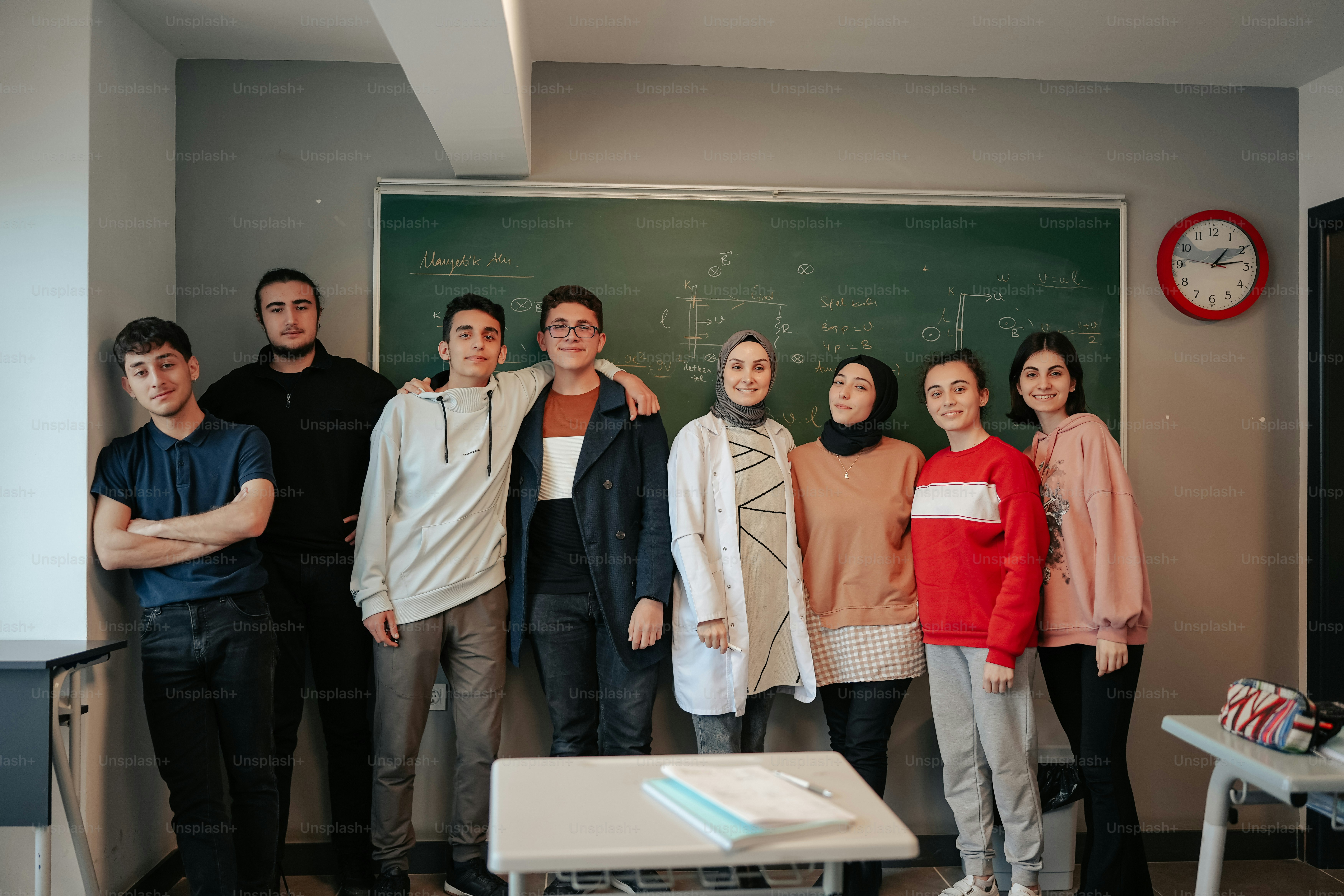a group of people standing in front of a blackboard